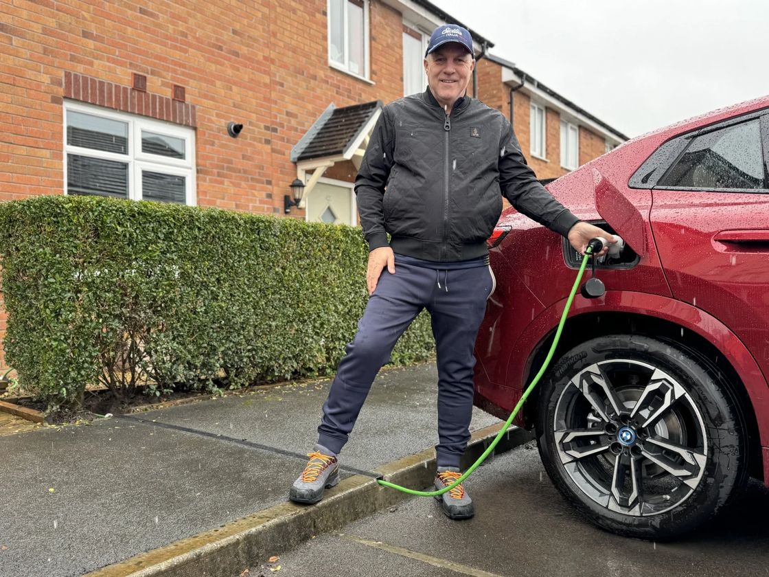 A resident charging his car through a newly installed channel